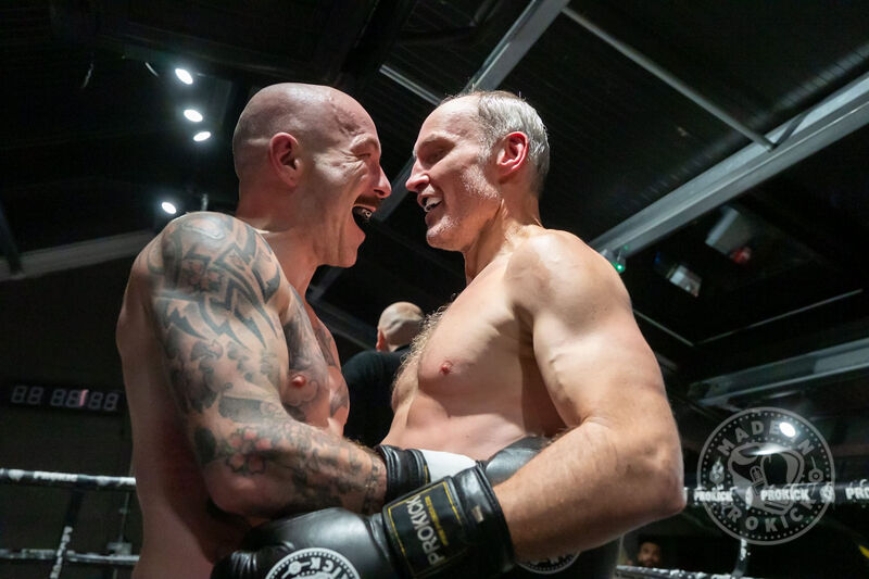 Celebrating the end of their trilogy match - When the judges rendered their decision, it was the red corner — Ian Young — who edged the victory. The crowd erupted for both men.