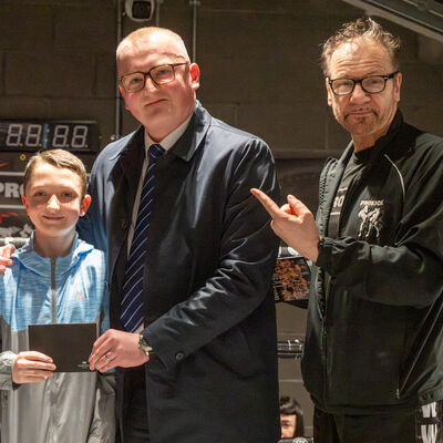 Ethan Martin, Operations Manager at the Stormont Hotel, proudly presents the winning ballot prize to the Robinson family.